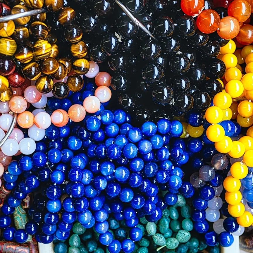 An assortment of loose glass beads in cobalt, amber, berry and gold ready to be strung