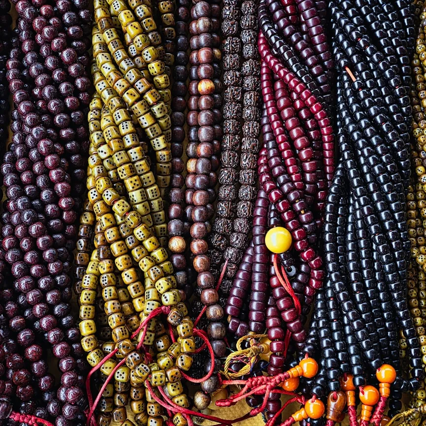 Bundle of multicolored beaded necklace strands in plum, gold and berry tones