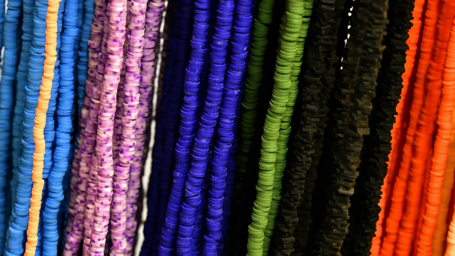 Strands of beads in every color of the rainbow hanging side by side